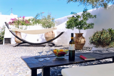 Mansion Sophia courtyard with table and wine in Megalochori Santorini