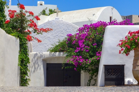 Mansion Sophia courtyard and door with flowers in Megalochori Santorini
